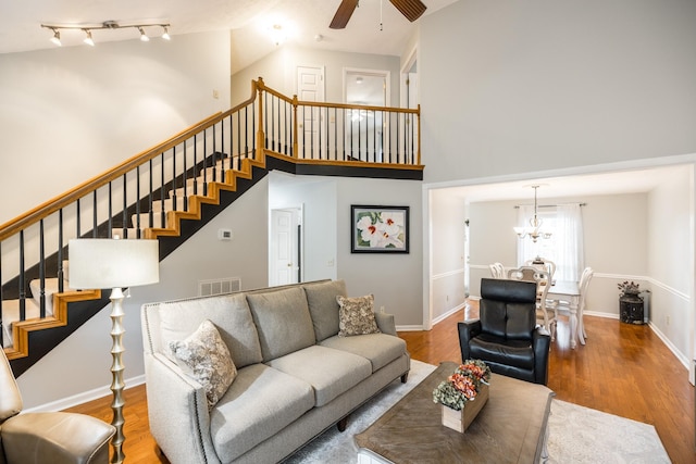 living room with stairs, a high ceiling, and wood finished floors