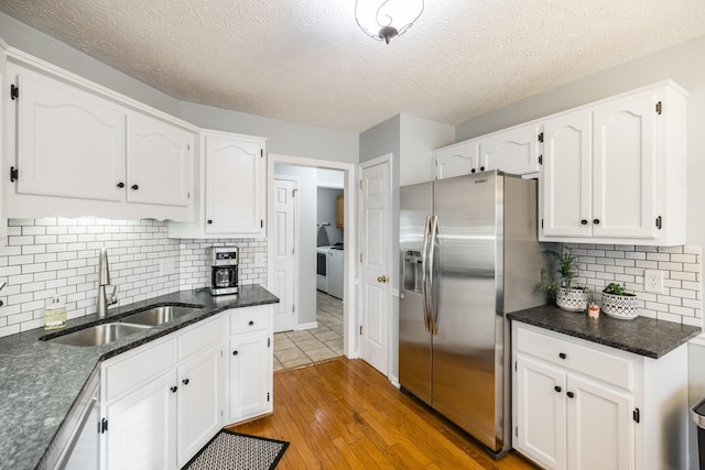 kitchen with light wood-style floors, stainless steel refrigerator with ice dispenser, a sink, and white cabinets