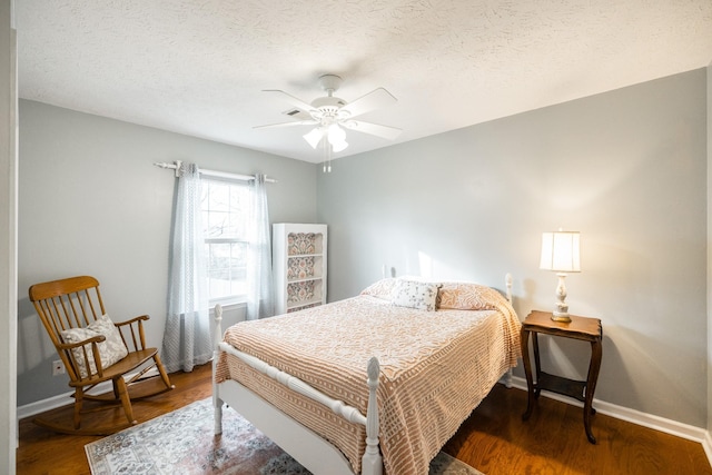 bedroom featuring a textured ceiling, ceiling fan, dark wood finished floors, and baseboards