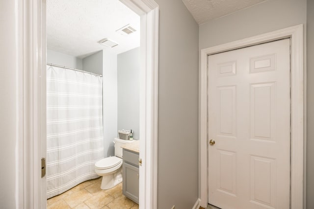 bathroom with visible vents, toilet, vanity, and a textured ceiling