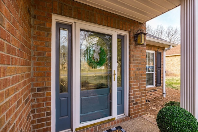 doorway to property featuring brick siding