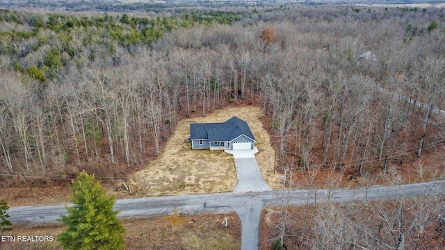 drone / aerial view with a wooded view