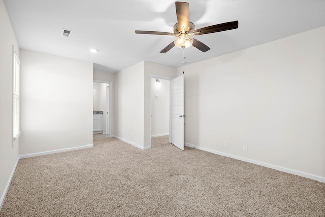 unfurnished bedroom with a ceiling fan, light carpet, visible vents, and baseboards