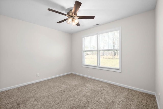 empty room featuring carpet floors, visible vents, and baseboards