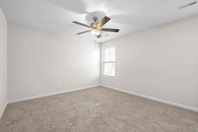 empty room with carpet floors, visible vents, ceiling fan, and baseboards