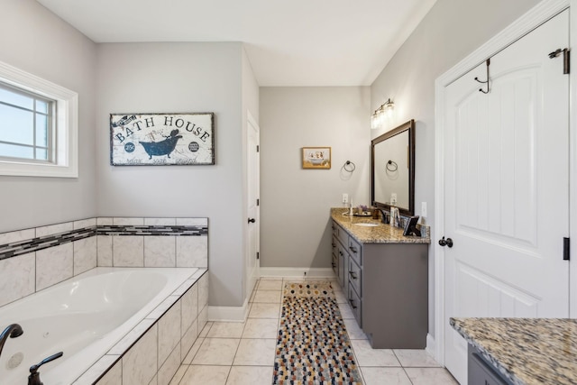 full bathroom with tile patterned flooring, vanity, baseboards, and a bath