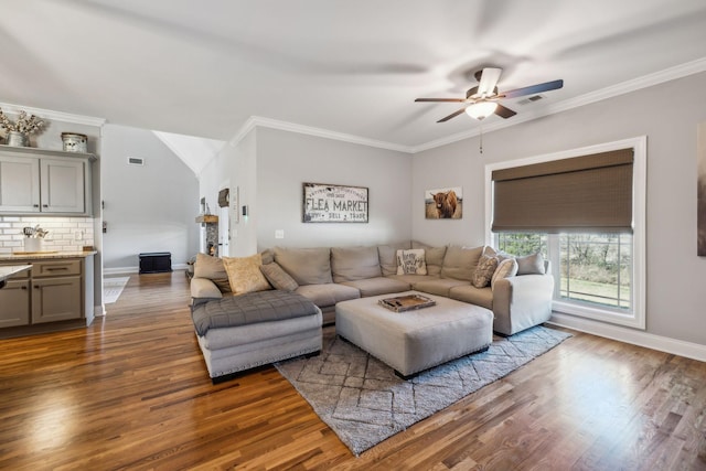 living area featuring baseboards, ornamental molding, and wood finished floors