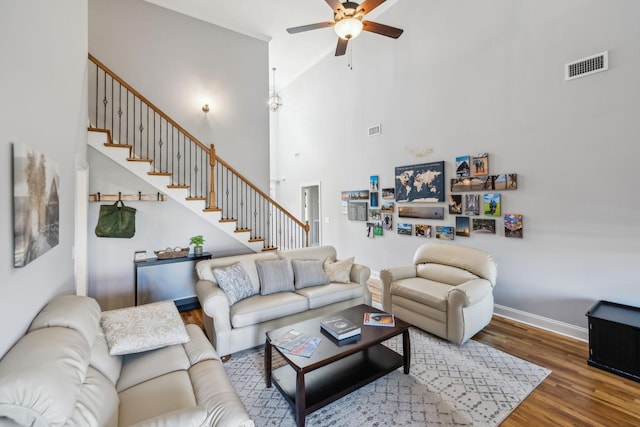 living room featuring stairs, wood finished floors, visible vents, and baseboards