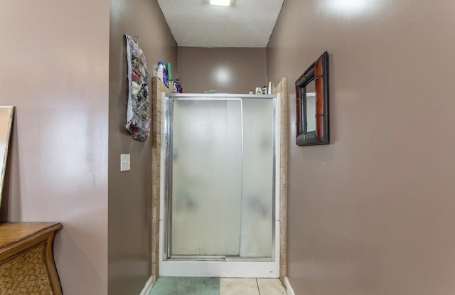 bathroom with a textured ceiling and a shower stall