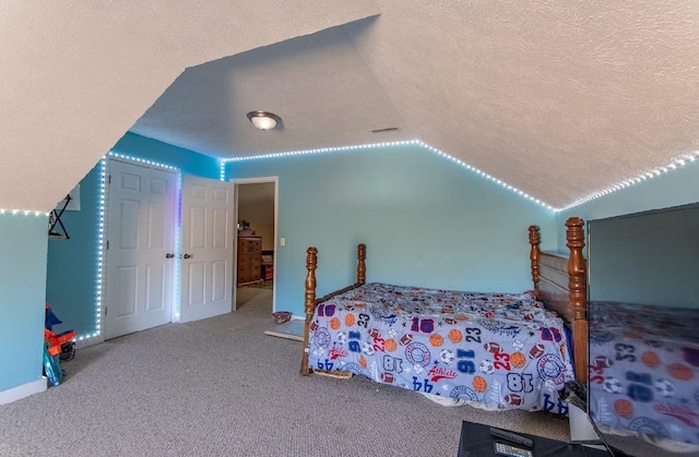 bedroom featuring visible vents, vaulted ceiling, a textured ceiling, and carpet flooring