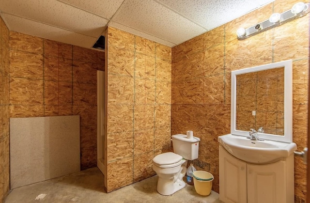 full bathroom with toilet, a drop ceiling, and vanity