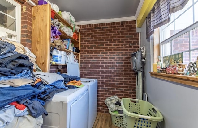 laundry room with brick wall, separate washer and dryer, laundry area, wood finished floors, and crown molding