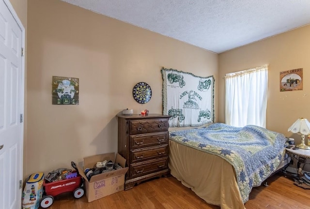 bedroom featuring a textured ceiling and wood finished floors