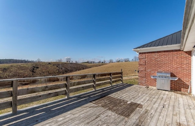 wooden terrace with a rural view and grilling area