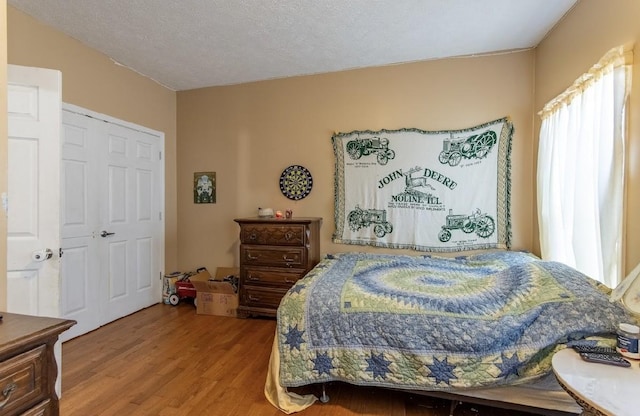 bedroom with a textured ceiling and wood finished floors