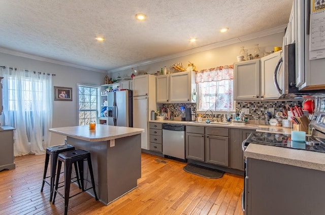 kitchen featuring a sink, light countertops, appliances with stainless steel finishes, and a kitchen island