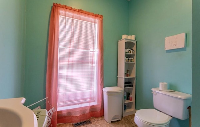 bathroom featuring toilet, a wealth of natural light, visible vents, and tile patterned floors