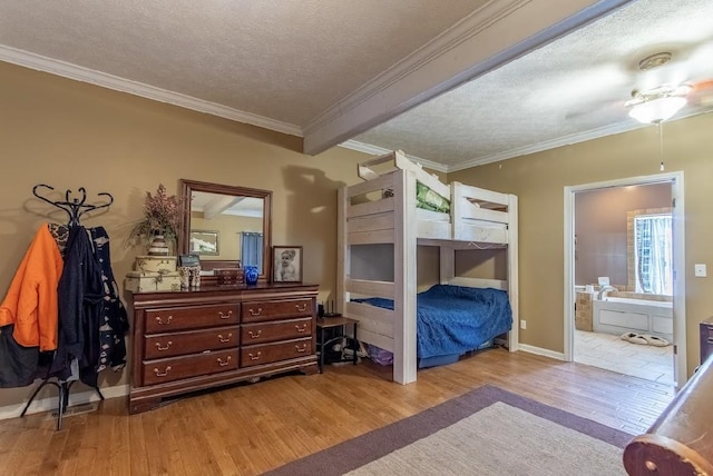 bedroom featuring a textured ceiling, ornamental molding, ensuite bath, and light wood-style flooring