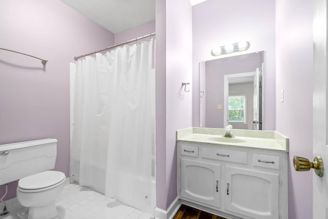 bathroom with toilet, shower / bath combo with shower curtain, vanity, and baseboards