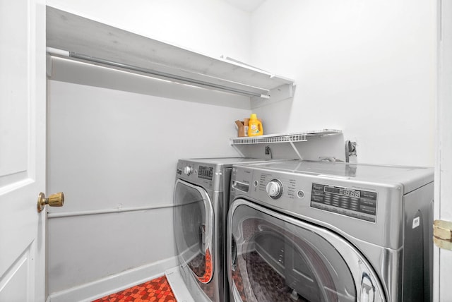 clothes washing area featuring laundry area, washing machine and clothes dryer, and baseboards