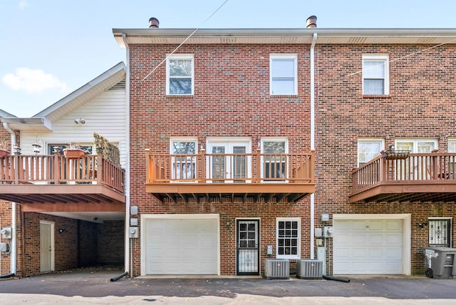 back of property with a garage and brick siding