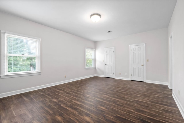 empty room featuring dark wood-style flooring and baseboards