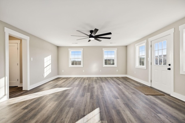 foyer entrance with dark wood-type flooring, a ceiling fan, and baseboards