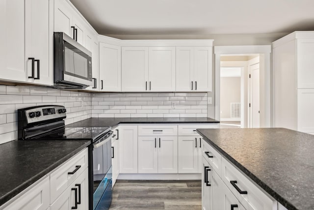 kitchen featuring stainless steel appliances, tasteful backsplash, wood finished floors, and white cabinets