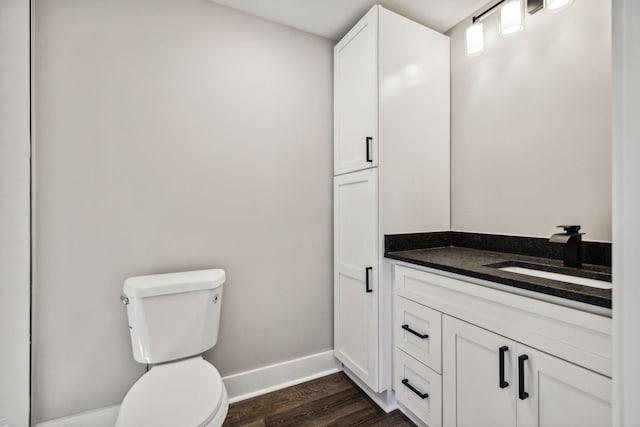 bathroom featuring vanity, wood finished floors, toilet, and baseboards