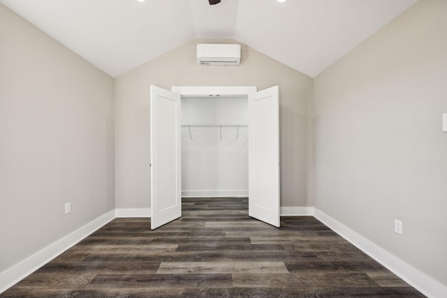 unfurnished bedroom with dark wood-style floors, a closet, vaulted ceiling, and baseboards