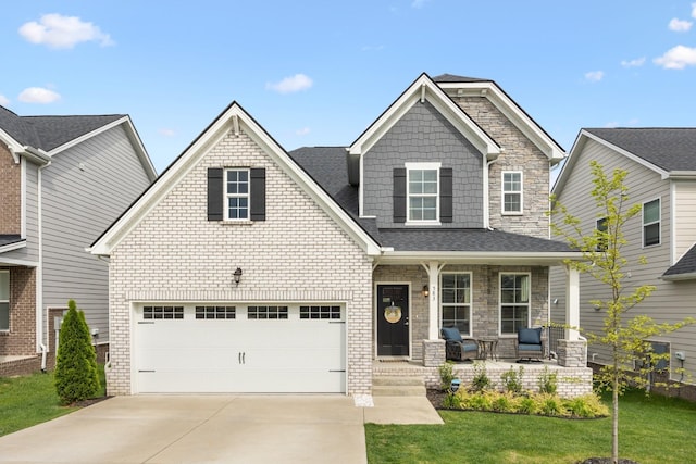 craftsman house with brick siding, a porch, a garage, driveway, and a front lawn