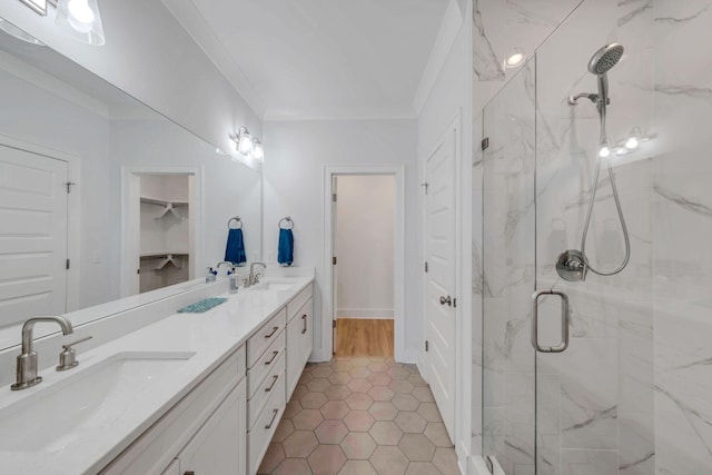 bathroom featuring double vanity, crown molding, a marble finish shower, and a sink