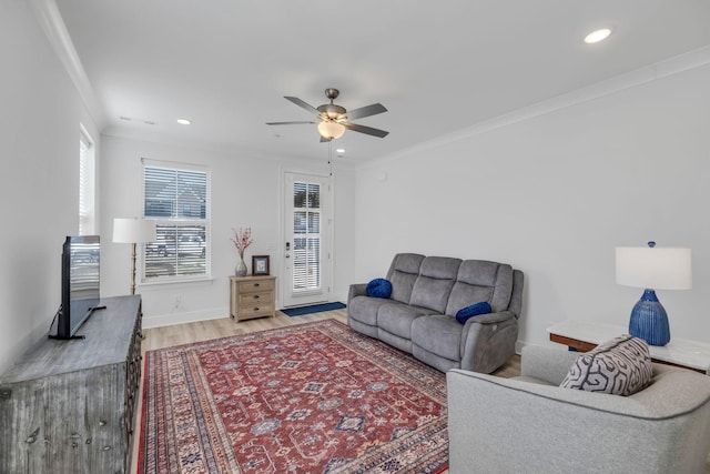 living room featuring light wood finished floors, ornamental molding, and recessed lighting