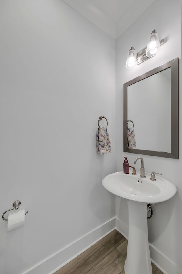 bathroom featuring a sink, wood finished floors, and baseboards