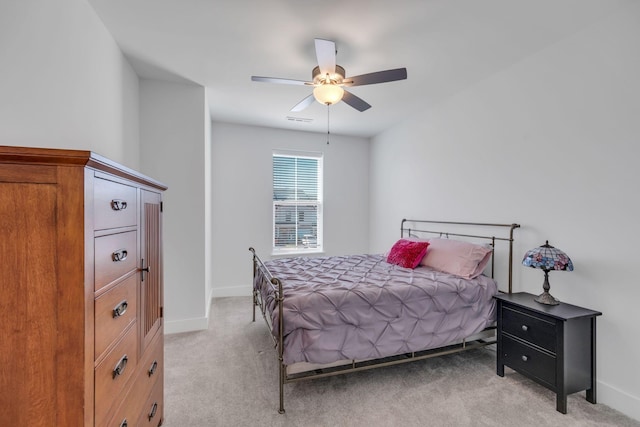 bedroom featuring a ceiling fan, light carpet, visible vents, and baseboards