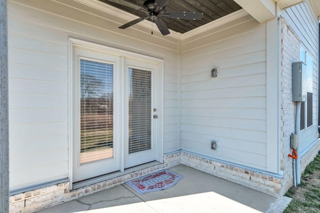 doorway to property with a ceiling fan and brick siding