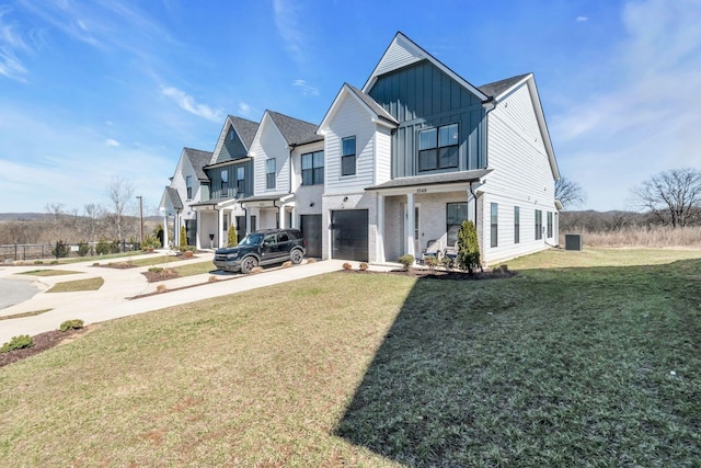 modern farmhouse with a garage, a front yard, board and batten siding, and concrete driveway