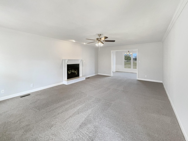 unfurnished living room with a fireplace with raised hearth, carpet flooring, visible vents, and baseboards