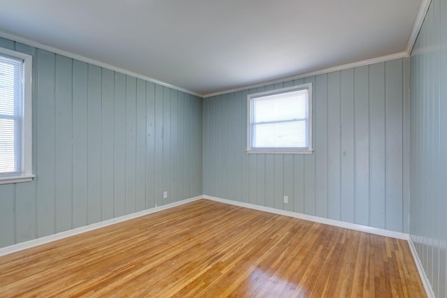 unfurnished room with light wood-style flooring, baseboards, and crown molding