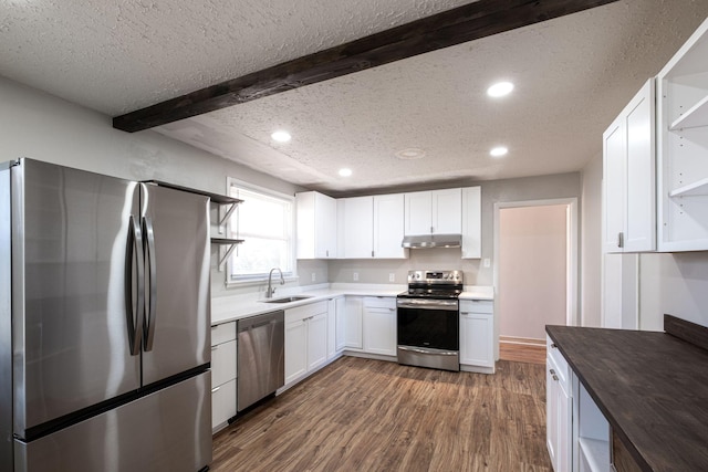 kitchen with under cabinet range hood, a sink, white cabinets, appliances with stainless steel finishes, and open shelves