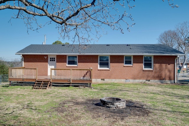 rear view of property featuring a fire pit, brick siding, crawl space, and a wooden deck