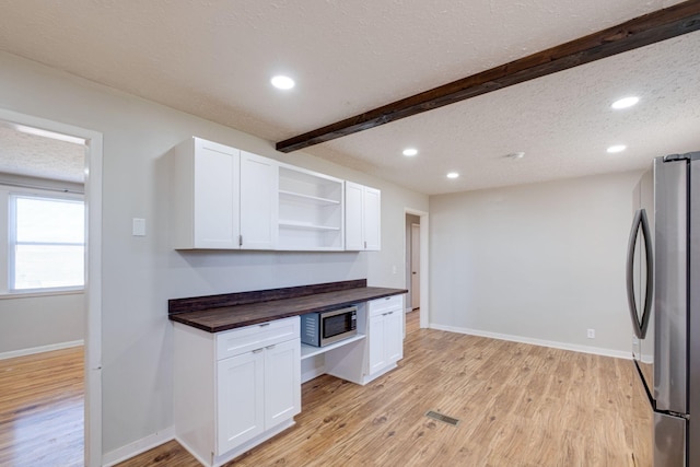 kitchen with open shelves, appliances with stainless steel finishes, wooden counters, and white cabinetry