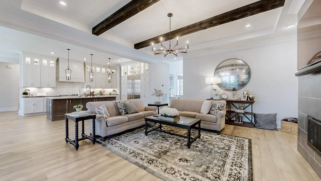 living room featuring recessed lighting, beam ceiling, light wood finished floors, and an inviting chandelier