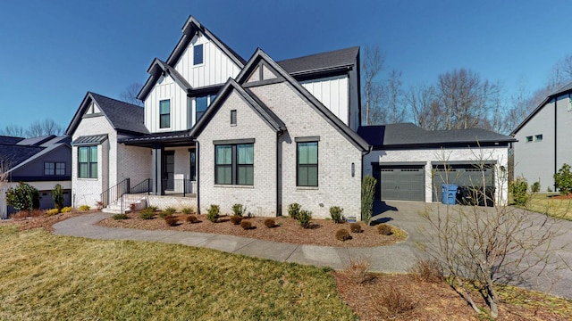 view of front of property with concrete driveway, an attached garage, a front yard, board and batten siding, and brick siding