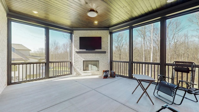 sunroom / solarium featuring wooden ceiling and a fireplace