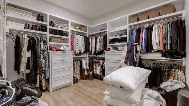 walk in closet with light wood-style floors