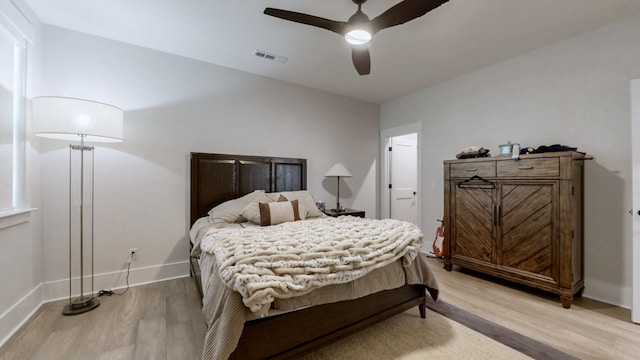 bedroom with a ceiling fan, light wood-type flooring, and baseboards