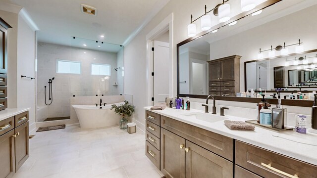 full bathroom featuring a stall shower, a freestanding tub, vanity, and baseboards