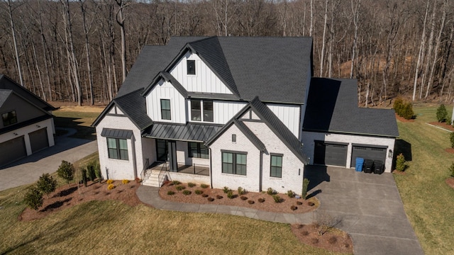 modern farmhouse style home featuring a porch, a front lawn, board and batten siding, and a forest view