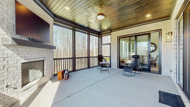 sunroom / solarium featuring visible vents, an outdoor brick fireplace, and wood ceiling